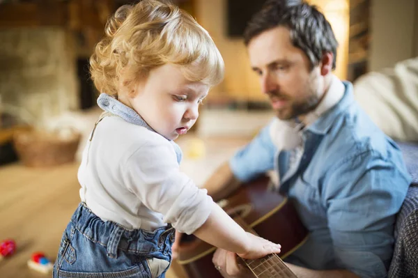 Baba ve oğul evde birlikte gitar çalmak. — Stok fotoğraf