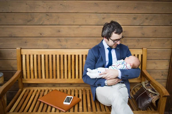 正面玄関の上に座っての赤ん坊の娘を持ったビジネスマン. — ストック写真