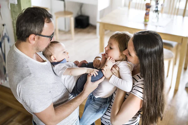 Beautiful young parents holding their cute little children — Stock Photo, Image