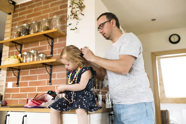 Junger Vater zu Hause stylt Haare seiner kleinen Tochter. — Stockfoto