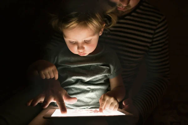 Padre con tableta e hija pequeña en casa por la noche . — Foto de Stock