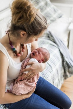 Genç anne evde yeni doğan bebek kızı holding