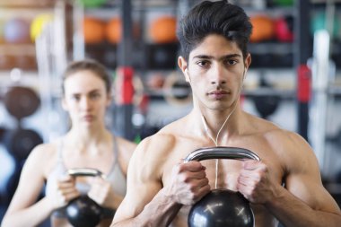 Genç çift kettlebell ile egzersiz spor salonunda yerleştirmek.