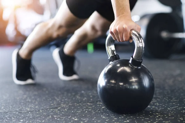 Onherkenbaar passen man in de sportschool doet push ups op kettlebells — Stockfoto