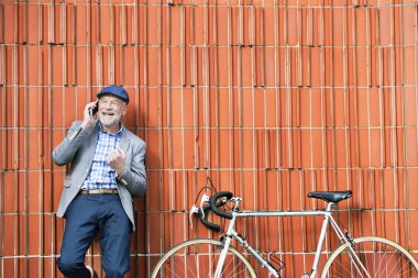 Üst düzey adam akıllı telefon ve duvara karşı Bisiklet.