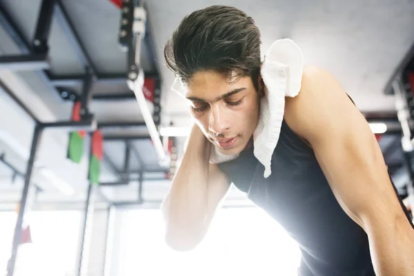 Ung träna spansktalande mannen i gymmet torka svett bort ansiktet — Stockfoto