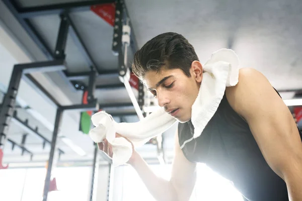 Ung träna spansktalande mannen i gymmet torka svett bort ansiktet — Stockfoto