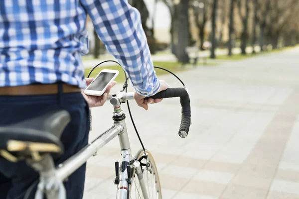 Hombre mayor con smartphone y bicicleta en la ciudad . — Foto de Stock