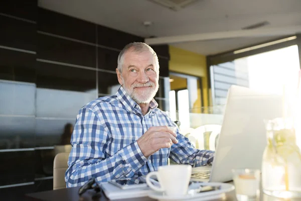 Старший бізнесмен працює на ноутбуці в кафе — стокове фото