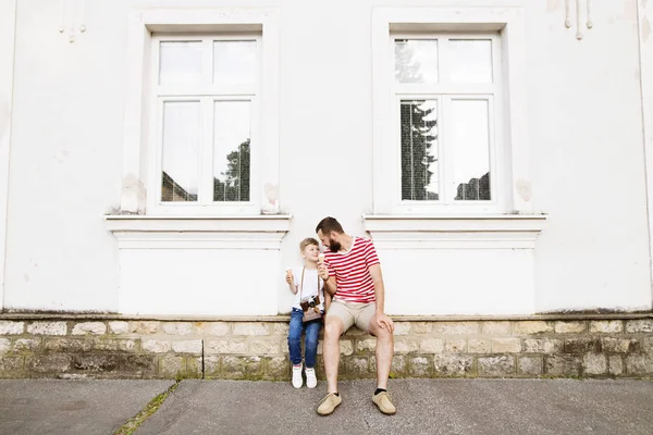 Un padre giovane e un figlio piccolo che mangiano gelato. Giornata di sole . — Foto Stock