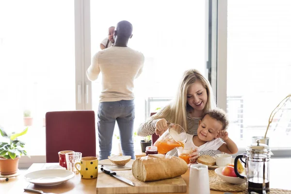 Young interracial family with little children having breakfast. — Stock Photo, Image