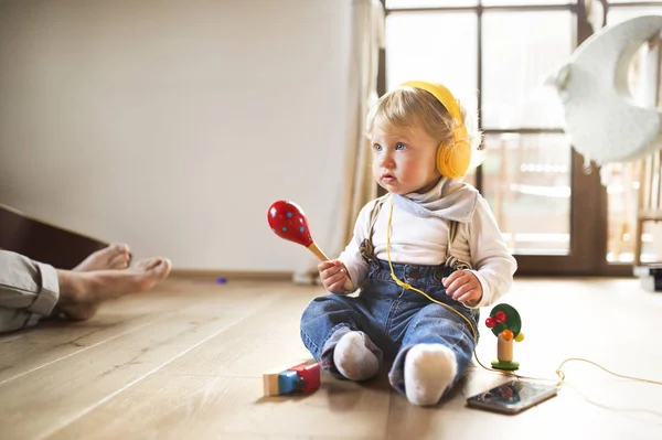 Liten pojke med hörlurar, musik, spelar musikaliska leksak — Stockfoto