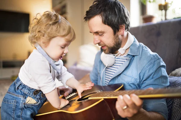 Vater und Sohn spielen zu Hause gemeinsam Gitarre. — Stockfoto