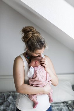 Genç anne evde yeni doğan bebek kızı holding