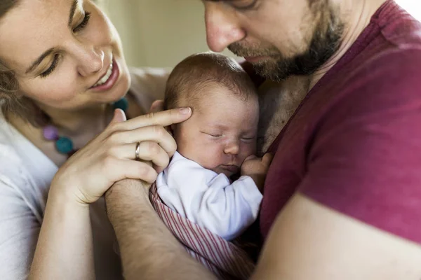 Hermosos padres jóvenes sosteniendo a su linda hija bebé . —  Fotos de Stock