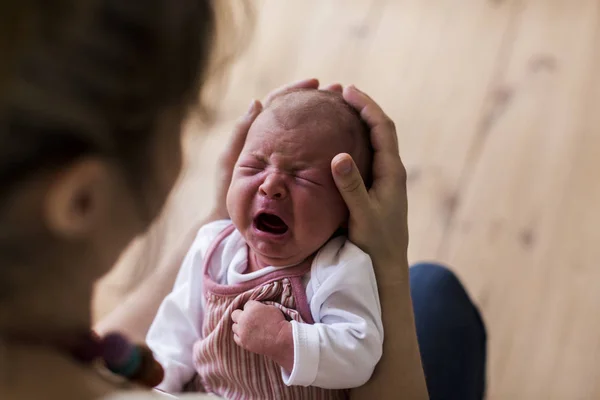Unrecognizable mother holding crying newborn baby girl. — Stock Photo, Image