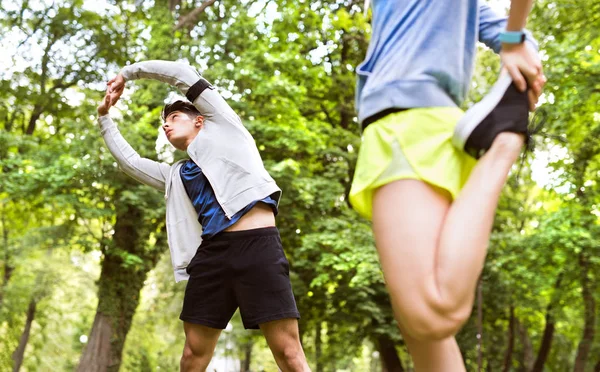 Aangelopen paar stretching en opwarming van de aarde in park voor opleiding — Stockfoto