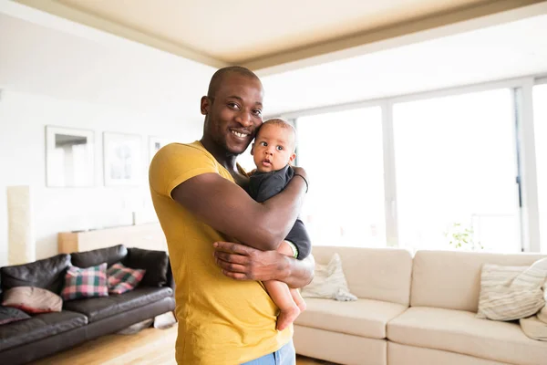 Młody afro-amerykański ojciec trzymający syna dziecko w ramionach — Zdjęcie stockowe