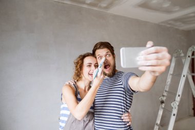Çift evde boyama duvarları selfie smartphone ile alarak,.