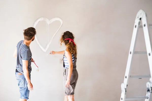 Pareja pintura corazón en la pared en su casa . — Foto de Stock