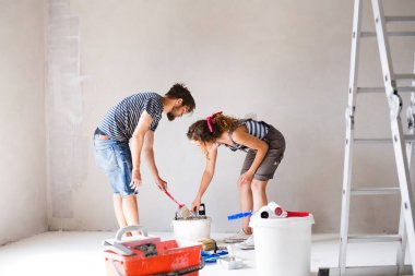 Genç çift yeni evlerinin duvarlarında resim.