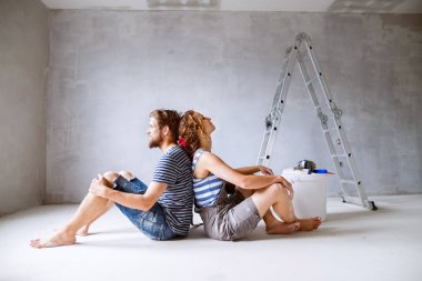 Genç çift yeni evlerinin duvarlarında resim.