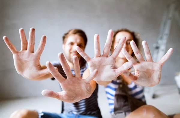 Pareja joven pintando paredes en su nueva casa . — Foto de Stock