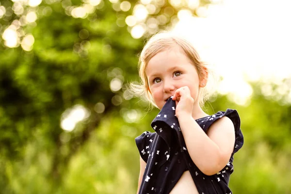 Söt liten flicka utanför i gröna solig sommar natur. — Stockfoto