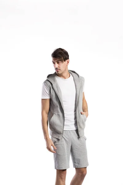 Bello fitness uomo in gilet con cappuccio, colpo in studio . — Foto Stock