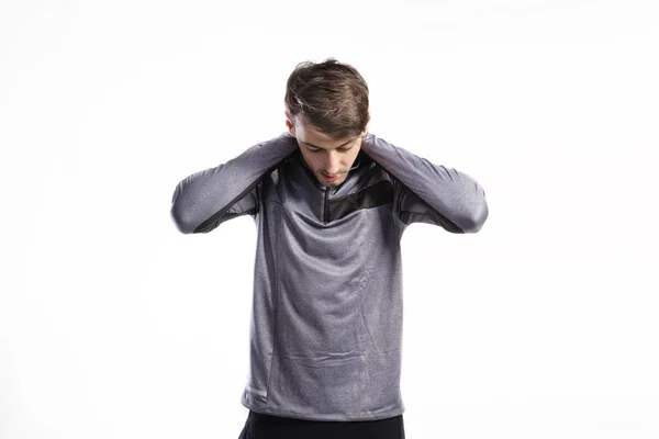 Fitter Mann im grauen Sweatshirt, die Arme ausstreckend, Studioaufnahme. — Stockfoto