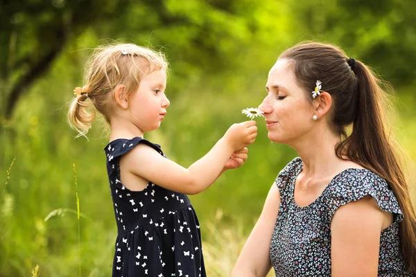 Mladá matka v přírodě s dcerou sladká malá. — Stock fotografie