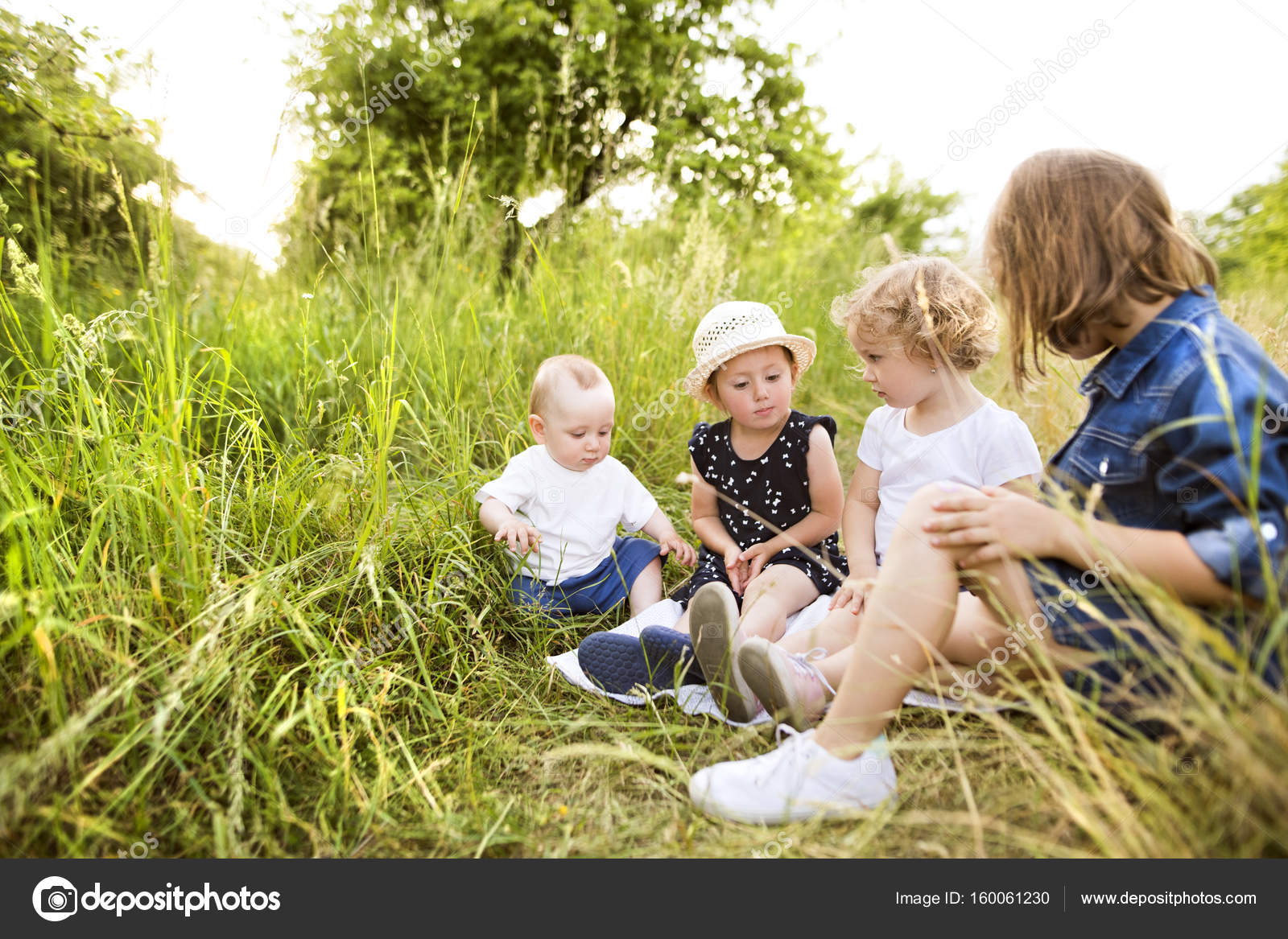 Cute little children outside in in green summer nature. Stock Photo by