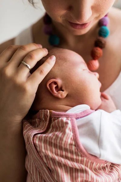 Mãe irreconhecível em casa segurando sua filha recém-nascida — Fotografia de Stock