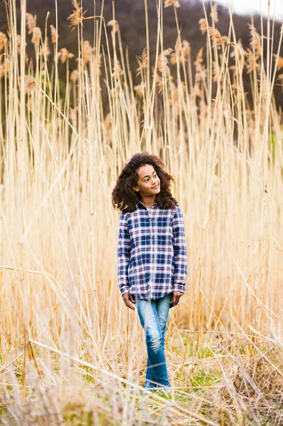 Афро-американських дівчина в зареєстрованого сорочку на відкритому повітрі в галузі. — стокове фото