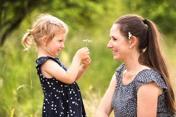 Jonge moeder in de natuur met haar zoete dochtertje. — Stockfoto