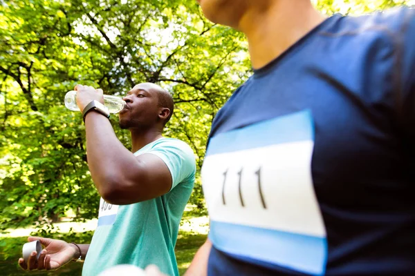 Two young athletes prepared for run, drinking water. — Stock Photo, Image