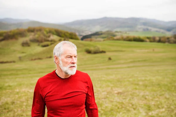 Actieve senior runner in rode trui in de rust van de natuur. — Stockfoto