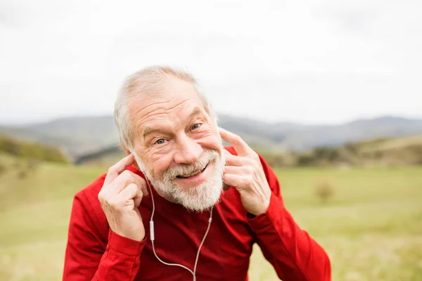 Coureur senior actif dans la nature au repos, écouter de la musique . — Photo