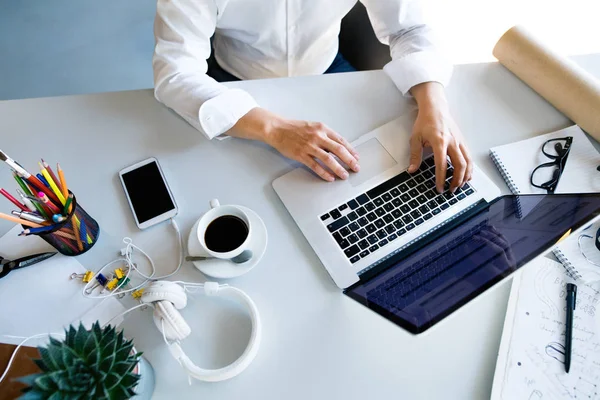 Zakenvrouw aan de balie met laptop in haar kantoor. — Stockfoto