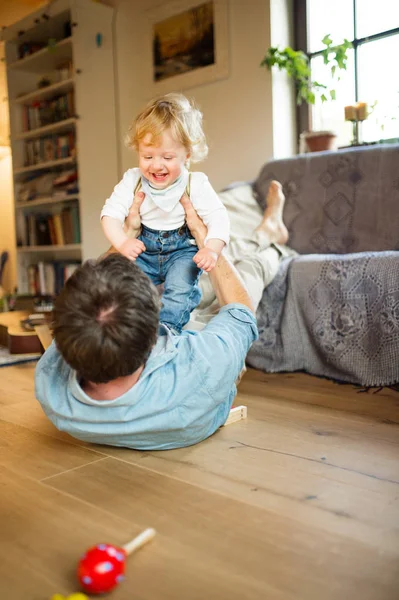 Jovem pai em casa brincando com seu filho . — Fotografia de Stock