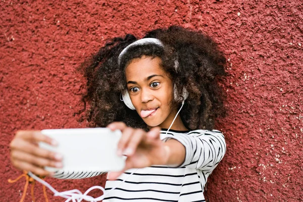 美丽的非洲裔美国女孩与智能手机和耳机. — 图库照片