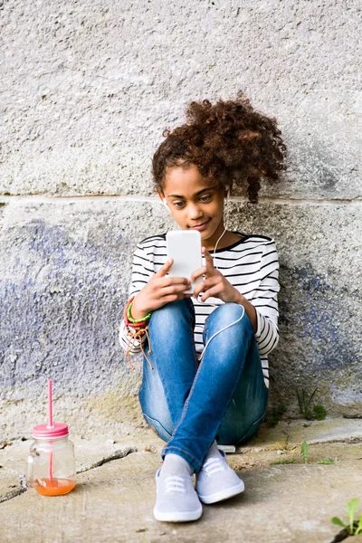 Красивая африканская американская девушка со смартфоном и напитками . — стоковое фото