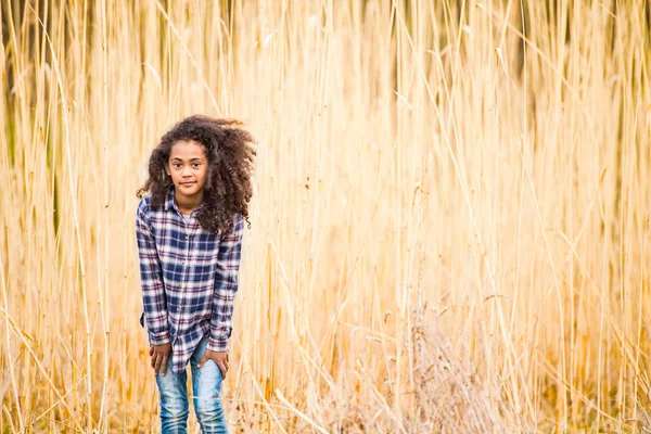 African american girl i rutig skjorta utomhus i fältet. — Stockfoto