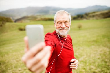 Selfie akıllı telefon ile alarak doğada aktif kıdemli koşucu.