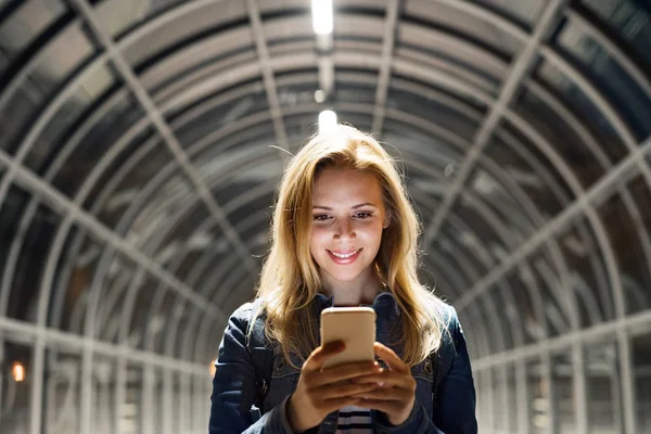 Mujer en la ciudad en la noche sosteniendo teléfono inteligente, mensajes de texto . —  Fotos de Stock