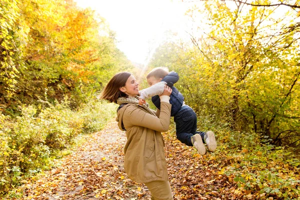 Sonbahar ormandaki oğluyla güzel genç anne. — Stok fotoğraf