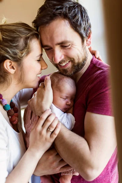 Vackra unga föräldrar håller sina söt baby dotter. — Stockfoto