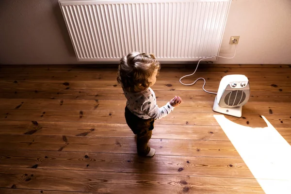 Lindo niño en casa de pie en el ventilador . — Foto de Stock