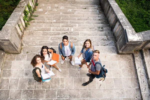 Estudiantes adolescentes en los escalones de piedra frente a la universidad . —  Fotos de Stock