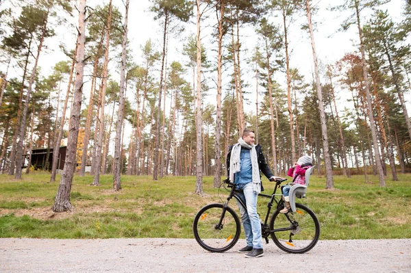 Junger Vater und Tochter gemeinsam auf Fahrrad im Herbstpark — Stockfoto